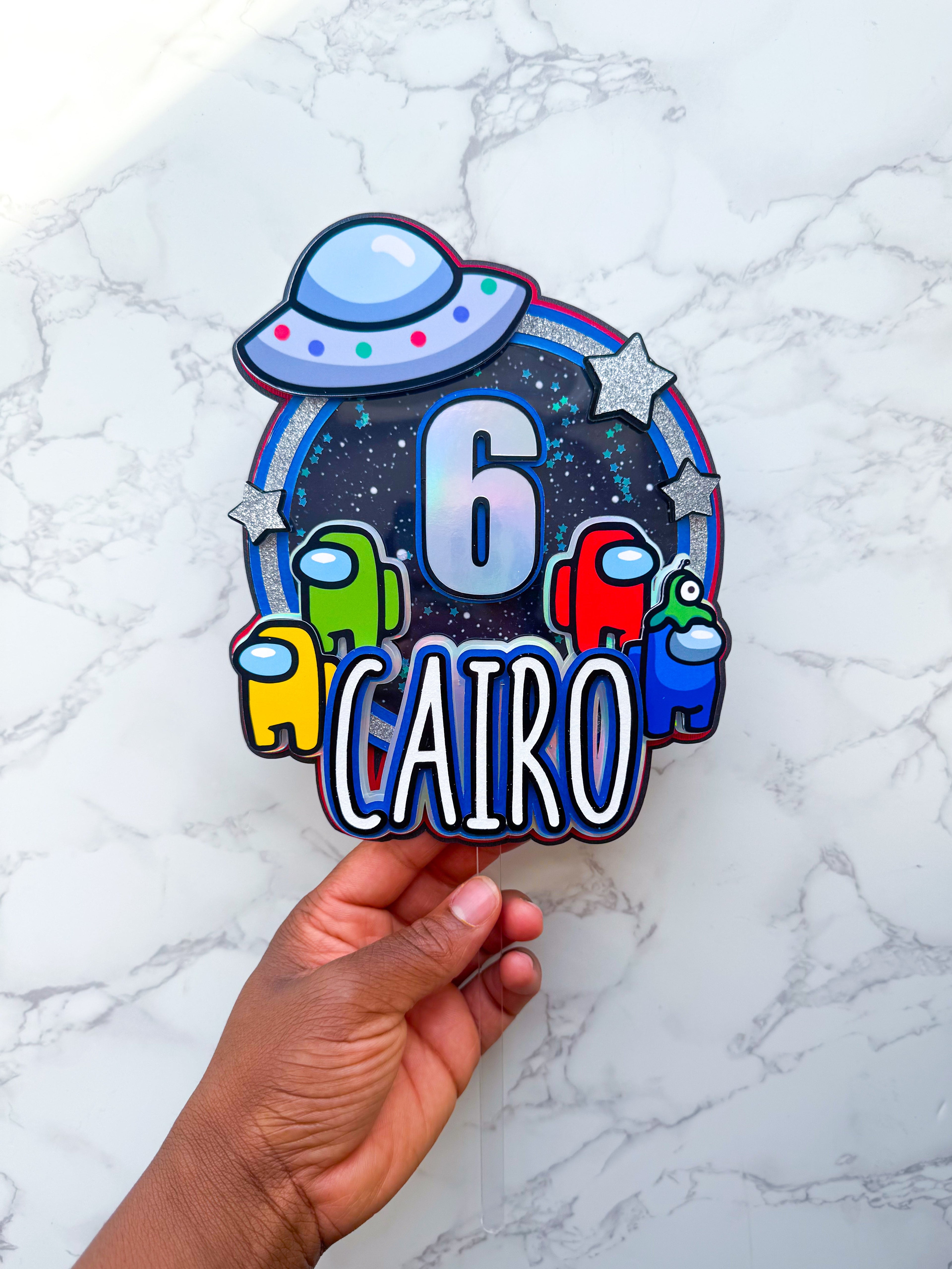 Colourful imposter birthday cake topper held